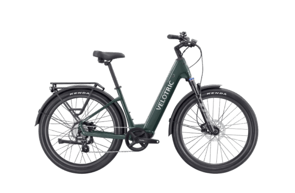 A dark green Velotric electric bicycle with step-through frame, rear cargo rack, front and rear fenders, and thick Kenda tires, displayed on a white background.